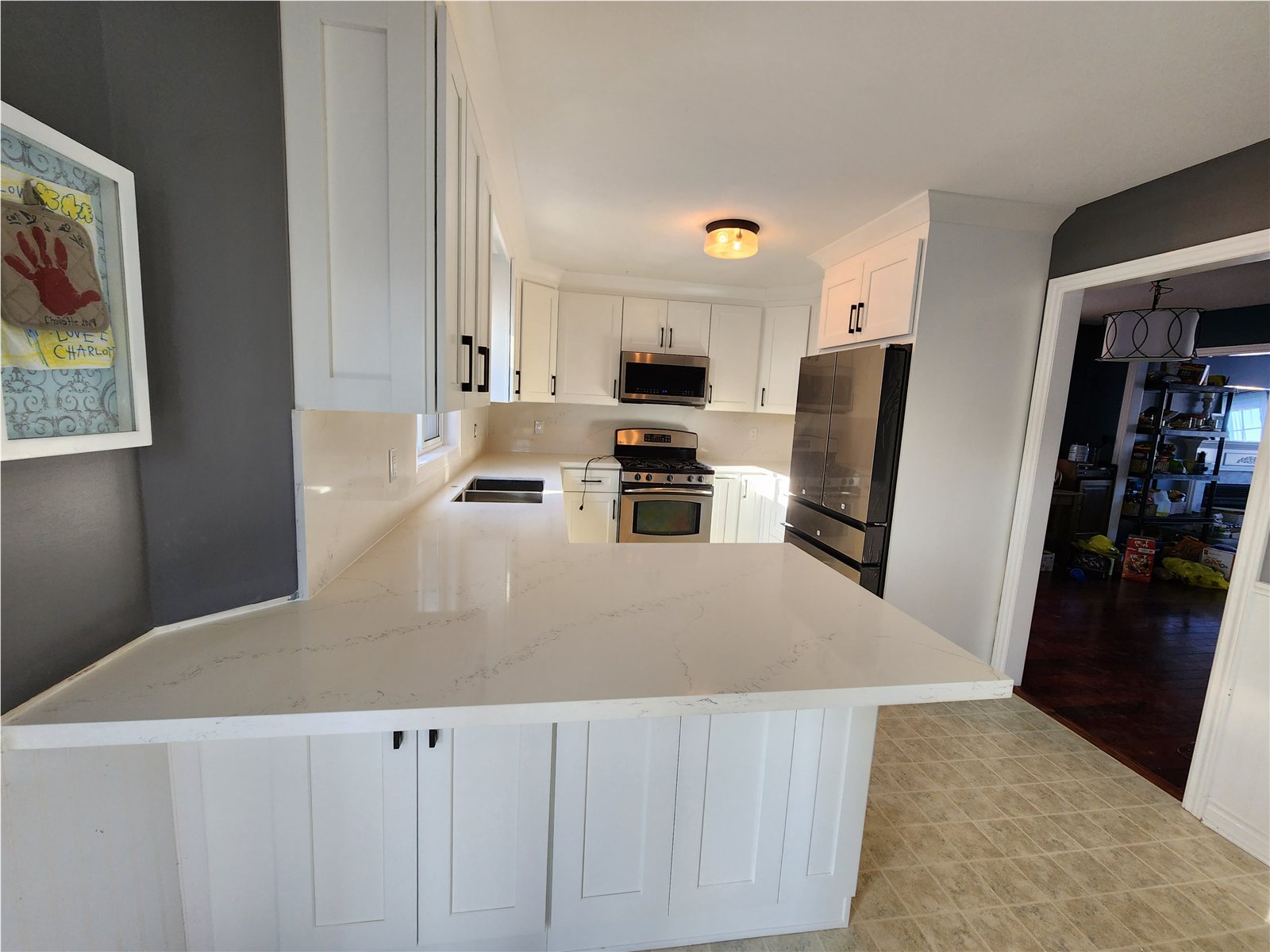 Barrie kitchen later with white shaker cabinets and a light countertop island