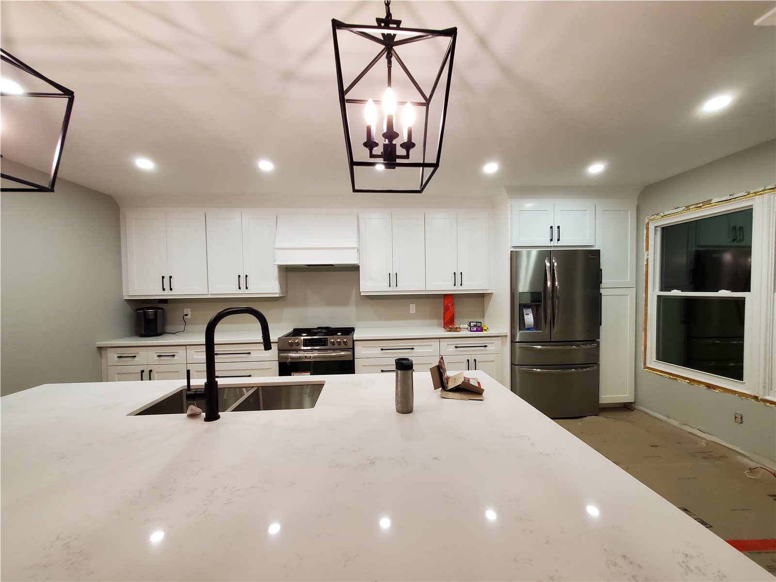 Clarington kitchen later in remodel with white shaker cabinets and a large island