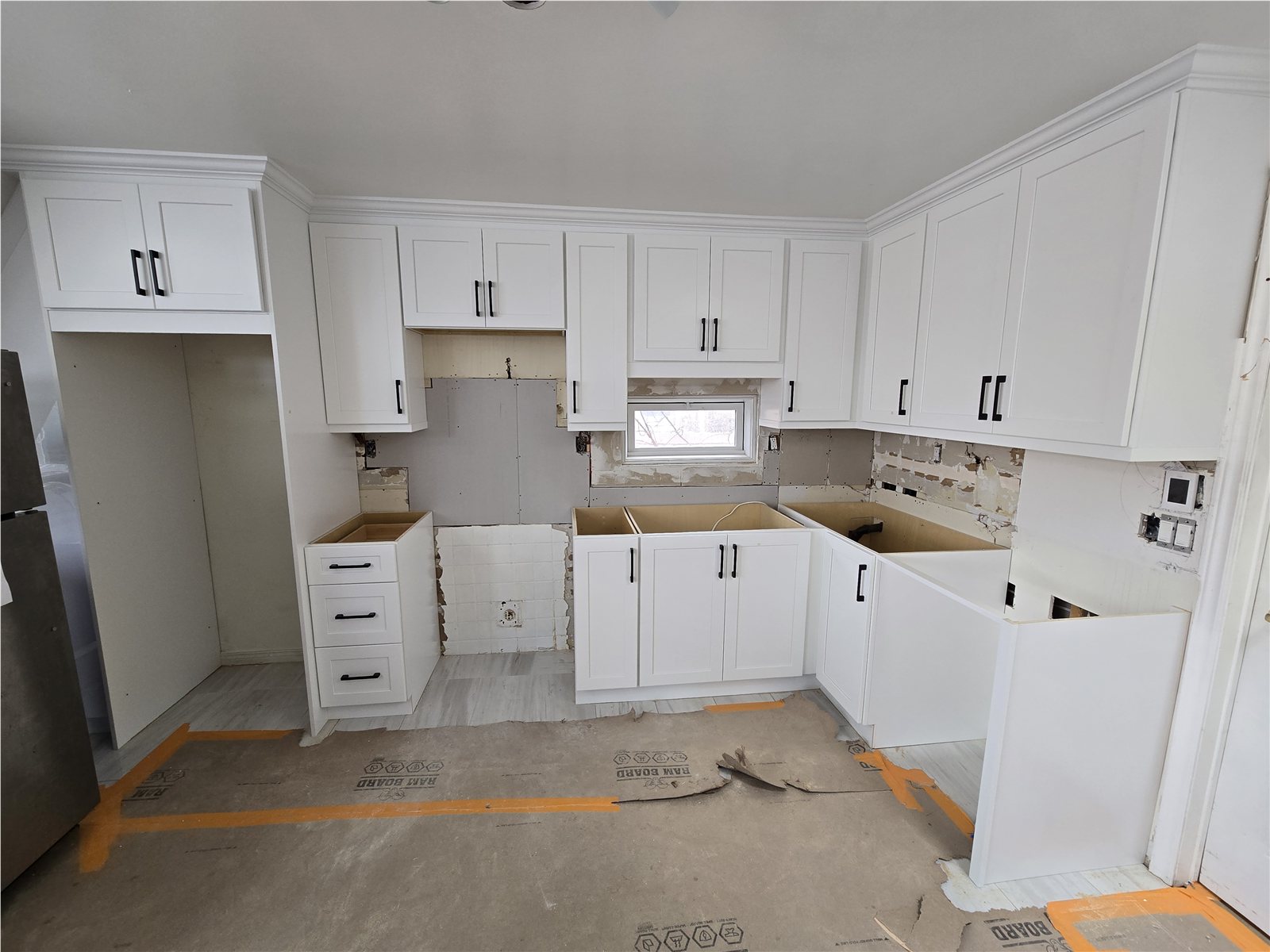 Toronto kitchen during white shaker cabinet installation with finishing work still visible